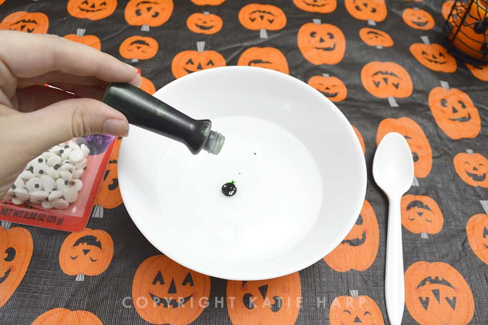 Adding green food coloring to the Halloween slime