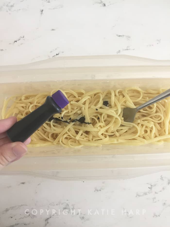 Adding purple food coloring to the pasta